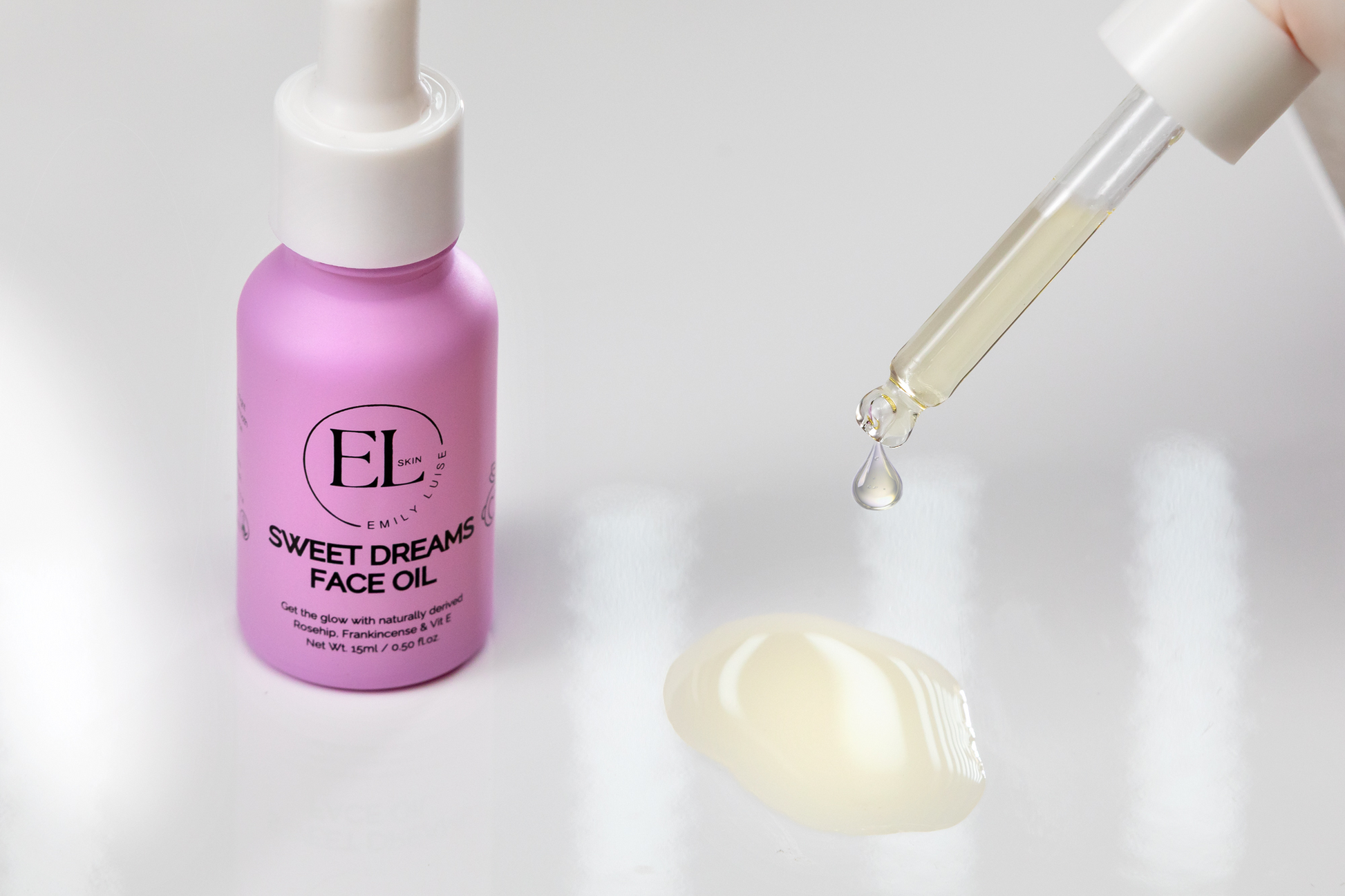 Purple bottle of Sweet Dreams Face Oil with dropper on a white background